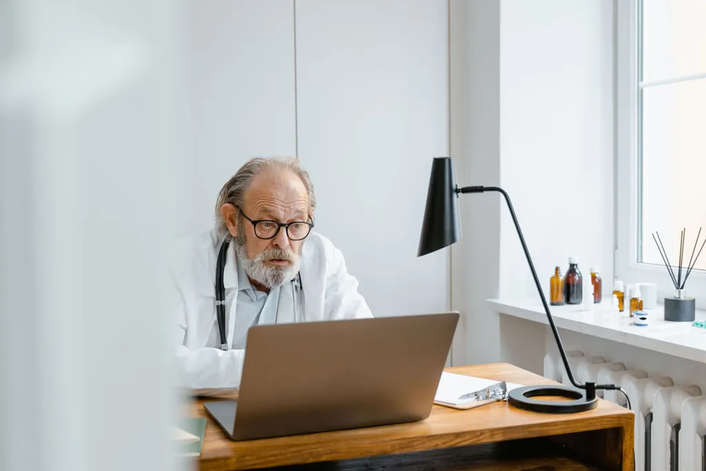 Physician working on a laptop at his desk