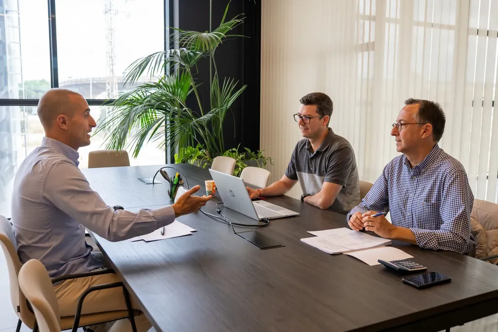 Three colleagues in a meeting at a conference table