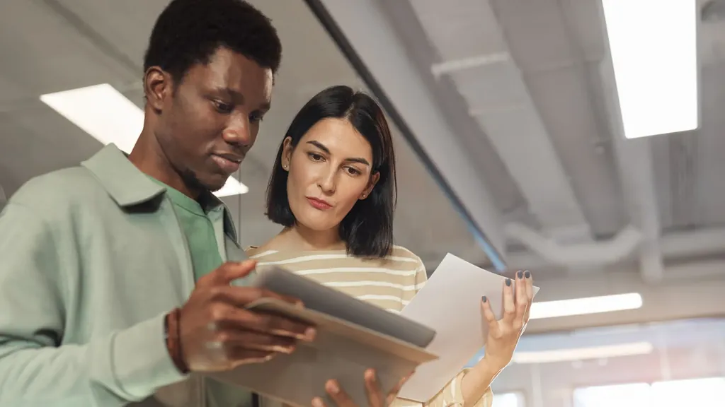 Two colleagues reviewing documents together