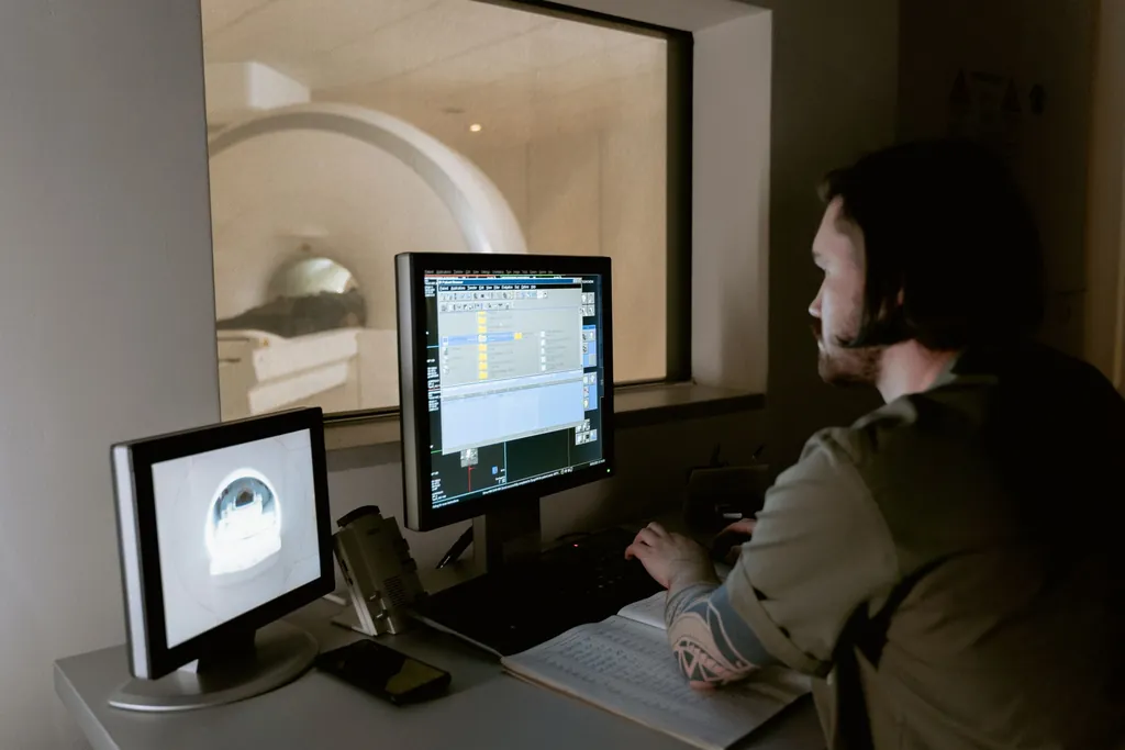 Technologist watching scan images on monitors in a control room