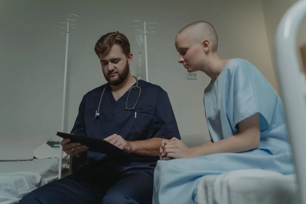 Doctor reviewing a tablet with a patient on a hospital ward