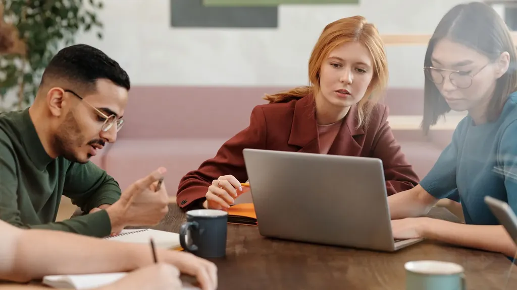 Three colleagues working together at laptops