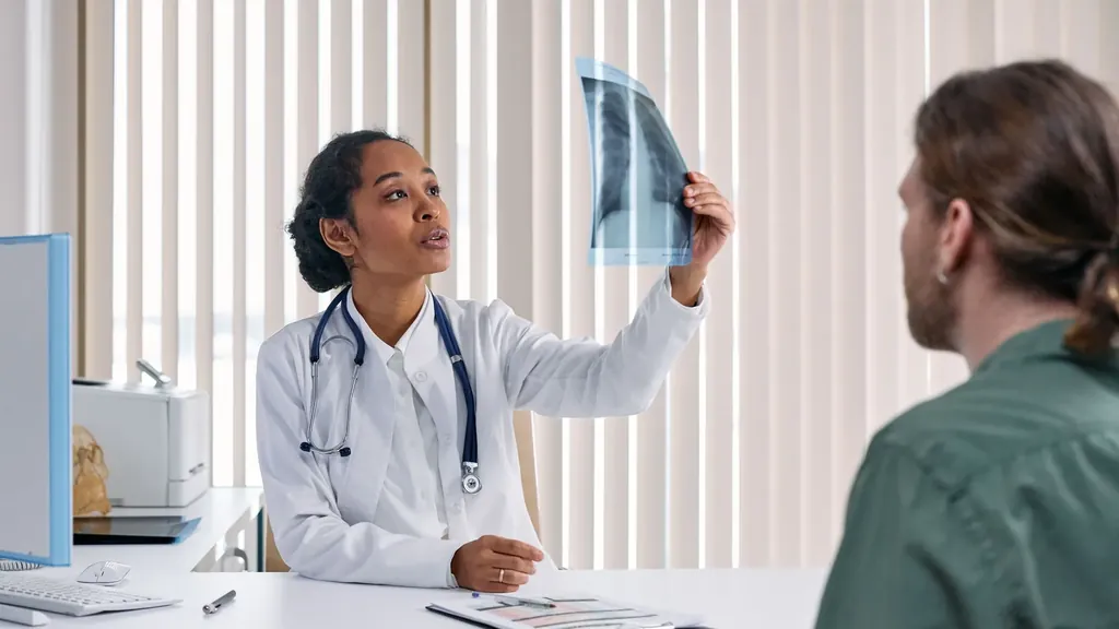 Pulmonologist reviewing a chest X-ray with a patient