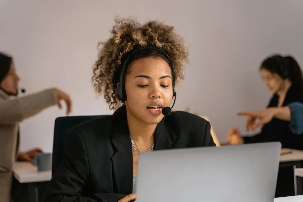 Billing specialist wearing a headset on a follow-up call at her laptop