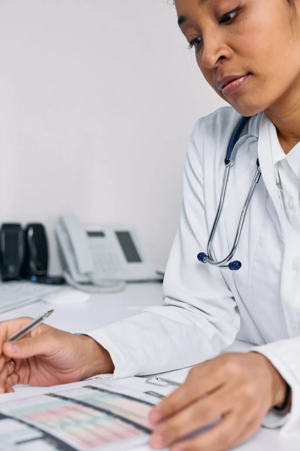 Physician filling out a patient record at her desk