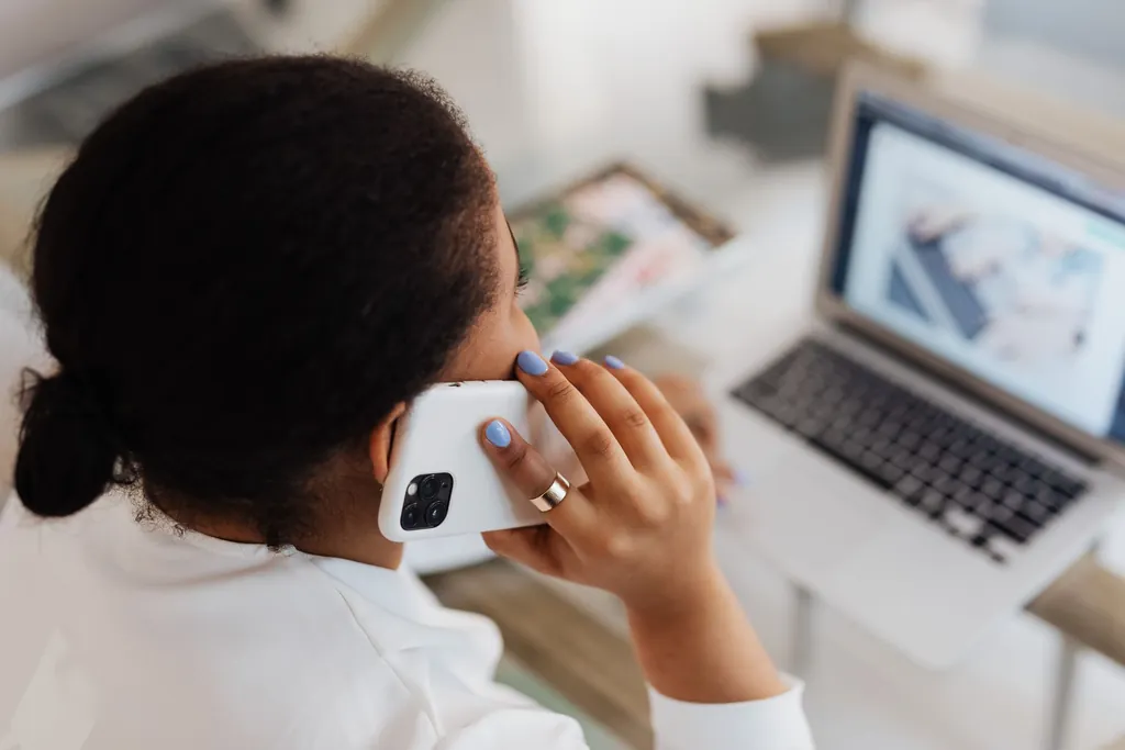 Billing specialist on a phone call beside an open laptop