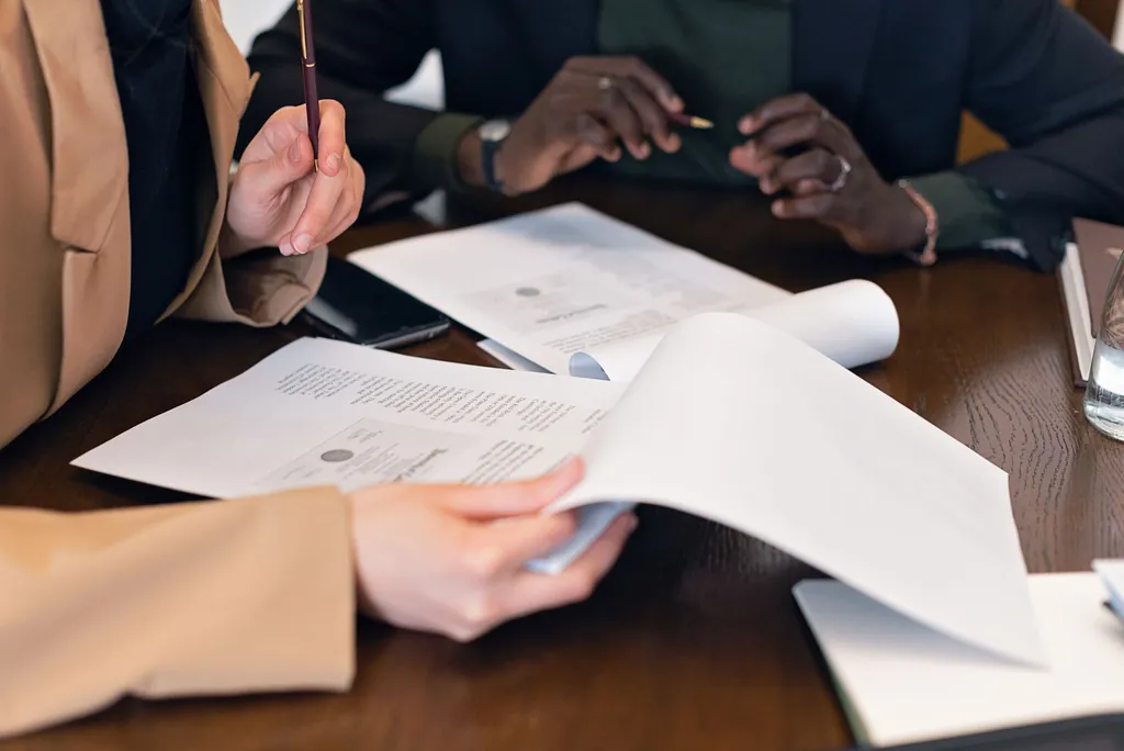Colleagues at a table reviewing printed claim documents together