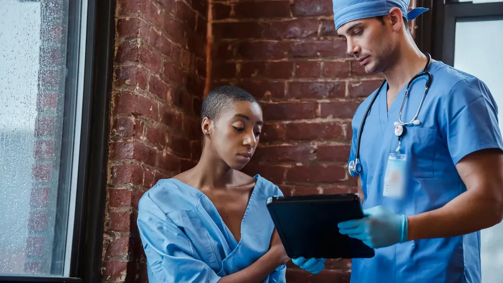 Clinician with a tablet talking with a patient