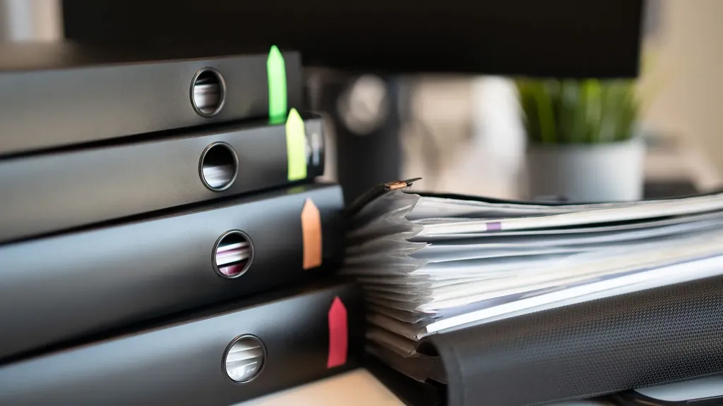 Ring binders and stacked documents on a desk
