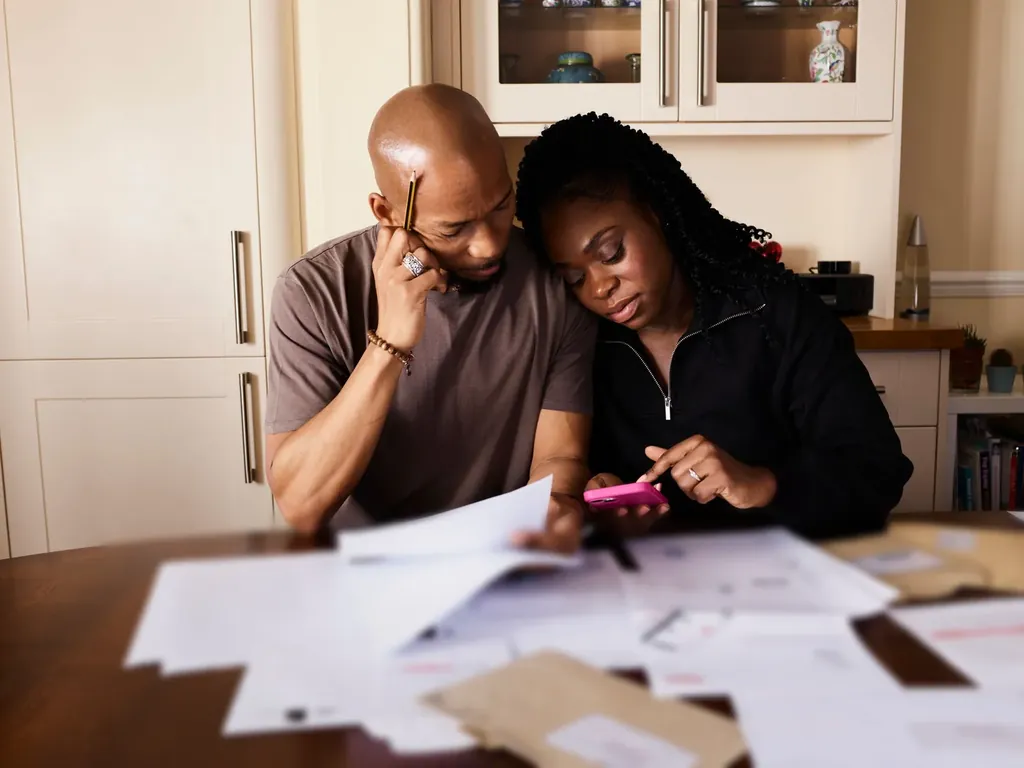 Couple sorting through bills at their dining table