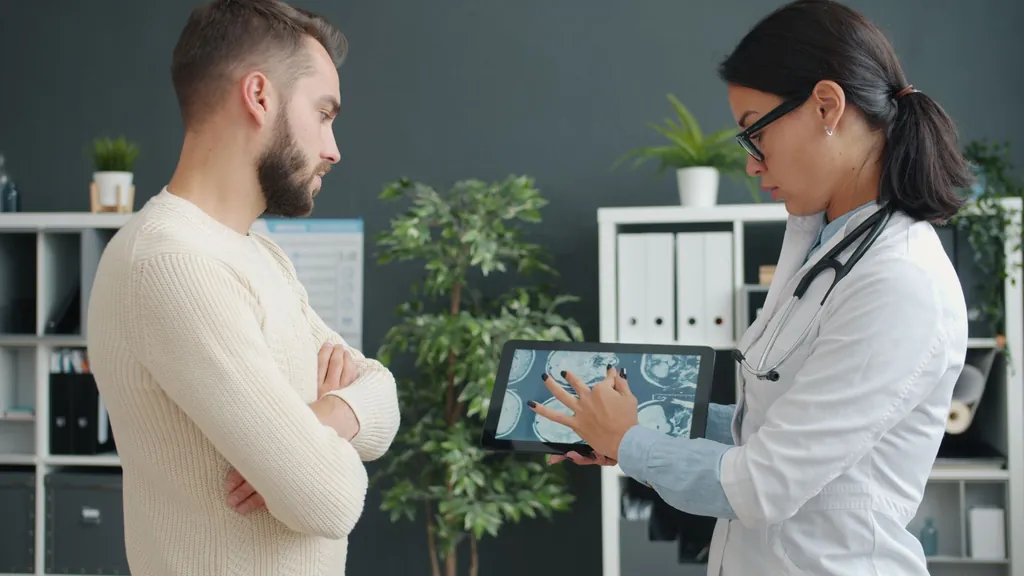 Physician showing scan results on a tablet to a patient